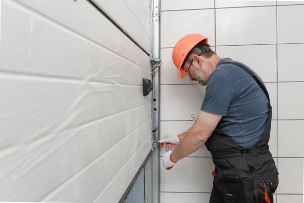 the worker is installing the lifting gates of the garage.