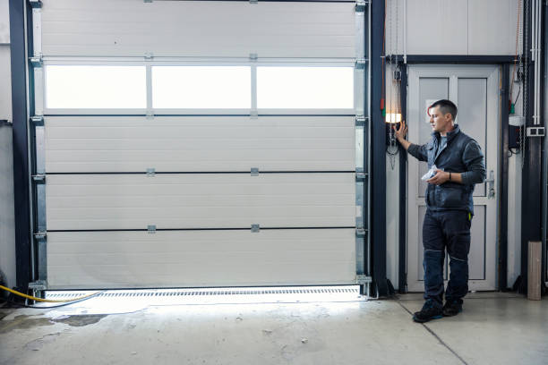 a mechanic is pressing button and opening garage door at the car workshop.